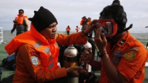 Des plongeurs se préparent à aller explorer la zone dans laquelle le vol QZ8501 a disparu des écrans radars. REUTERS/Beawiharta