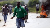 Des protestants jettent des pierres contre des policiers, le 21 mai à Bujumbura. REUTERS/Goran Tomasevic