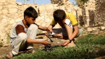 Deux enfants tiennent un morceau de débris de bombe lâché par l'aviation turc sur le village d'Amadiya en Irak du nord. REUTERS/Ari Jalal