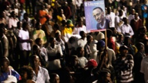 Les partisans de Paul Kagame brandissent un poster du président, élu depuis 2003 mais homme fort du pays depuis la fin du génocide en 1994. Photo: Finbarr O'Reilly/Reuters
