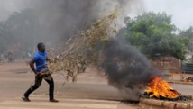 Un manifestant lance des branchages dans un brasier, à l'intersection de plusieurs rues, à Ouagadougou ce 18 septembre. REUTERS/Joe Penney