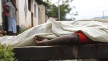 Des habitants regardent le corps d'un homme tué dans le quartier de Nyakabiga, à Bujumbura, le 12 décembre 2015. Les affrontements de vendredi à Bujumbura, la capitale du Burundi, ont fait 87 morts, a annoncé l'armée. © REUTERS/Jean Pierre Aime Harerimana