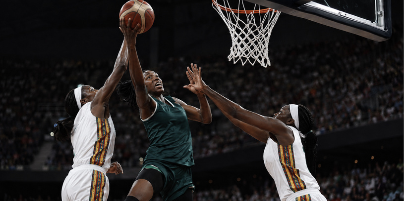 Alt: Des joueuses de basket luttent sous le panier