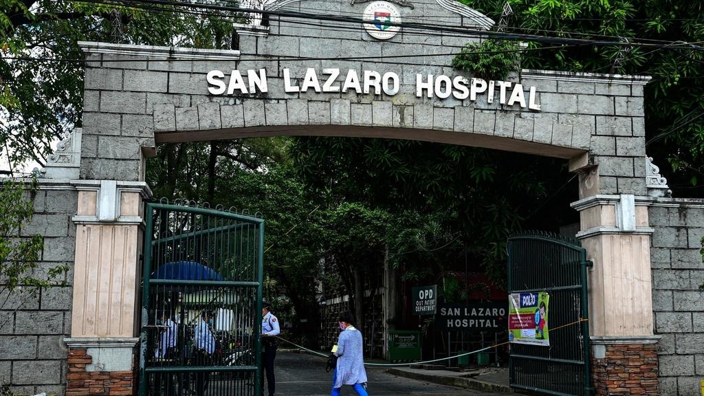 Des personnes portant des masques passent devant les portes principales de l'hôpital San Lazaro à Manille le 2 février 2020. Maria TAN / AFP
