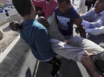 Un blessé transporté après les tirs d'une milice contre la foule venue demander son départ, le 15/11/13 à Tripoli, en Libye. REUTERS/Stringer