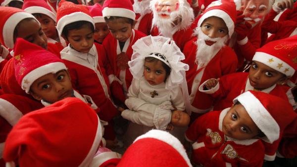 Enfants vêtus de costumes de père Noël autour d'une petite fille habillée comme la Vierge Marie lors des célébrations de Noël dans une église dans la ville indienne de Chandigarh . REUTERS/Ajay Verma