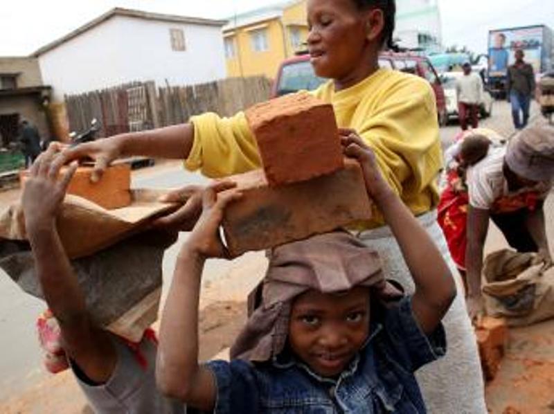 Des enfants travaillent à transporter des briques, à Antananarivo, le 19 décembre 2013. AFP PHOTO / ALEXANDER JOE