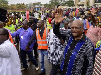 Roch Marc Christian Kabore (d.), ancien président de l'Assemblée nationale burkinabè, salue la foule à son arrivée dans le cortège de l'opposition, le 18 janvier 2014 à Ouagadougou. AFP PHOTO/AHMED OUOBA