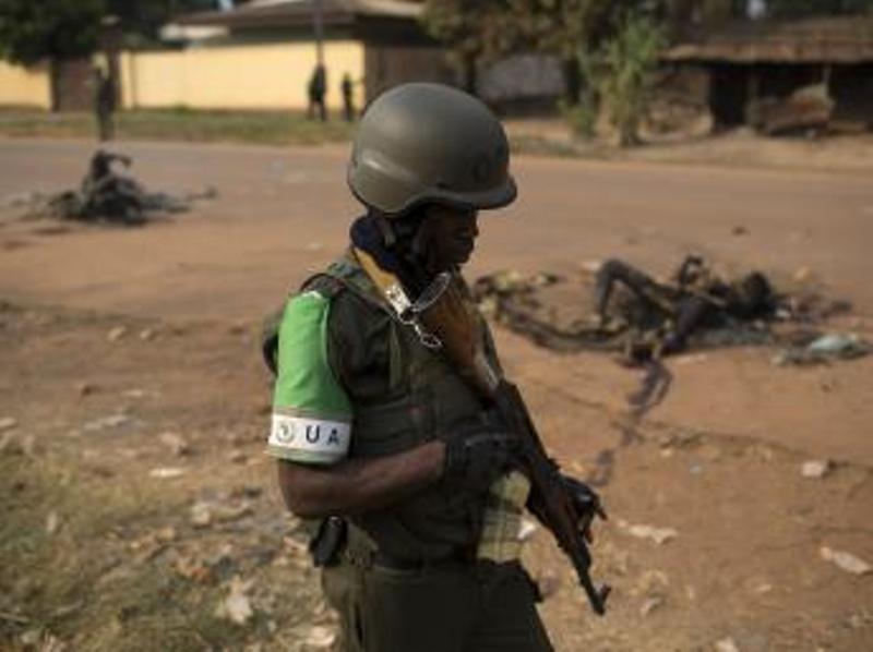 Un soldat de la Misca passe devant les corps calcinés de deux musulmans tués par une foule hostile, dimanche 26 janvier à Bangui. REUTERS/Siegfried Modola
