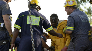 Des secouristes sortant les premiers rescapés de la mine illégale de Benoni près de Johannesburg le 16 Février 2014