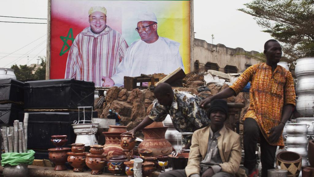 Des vendeurs de rue devant un poster géant du roi Mohammed VI et du président malien Ibrahim Boubacar Keïta, le 18 février 2014 à Bamako.