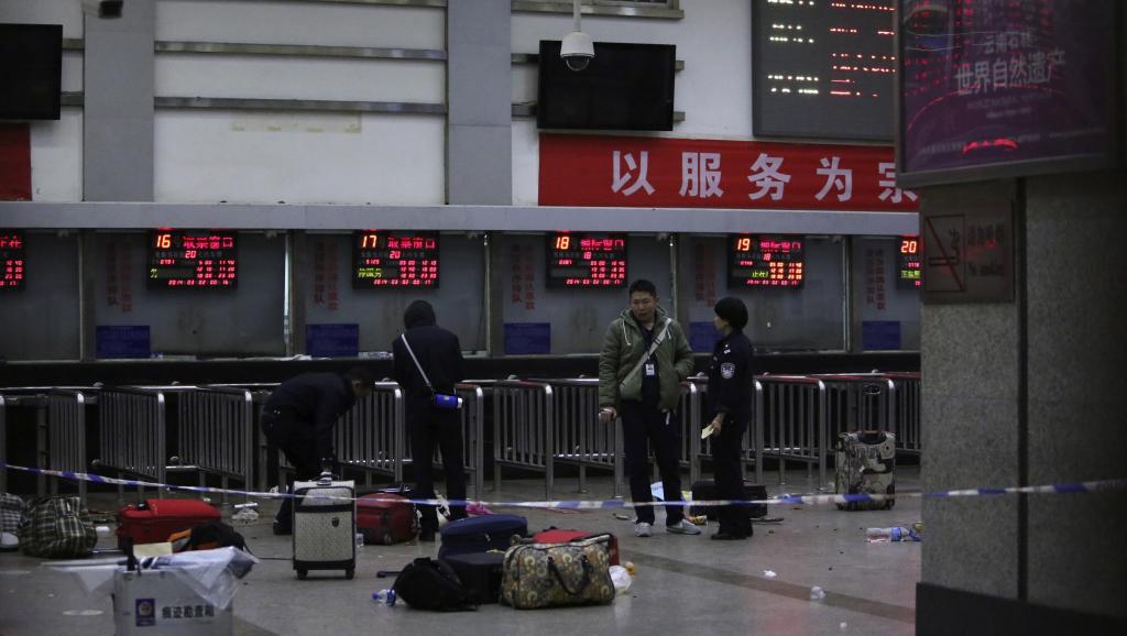 Des policiers se tiennent sur la scène des attaques aux couteaux qui ont eu lieu dans la gare de Kunming, dans la province du Yunnan, en Chine, le 2 mars 2014. REUTERS/Stringer