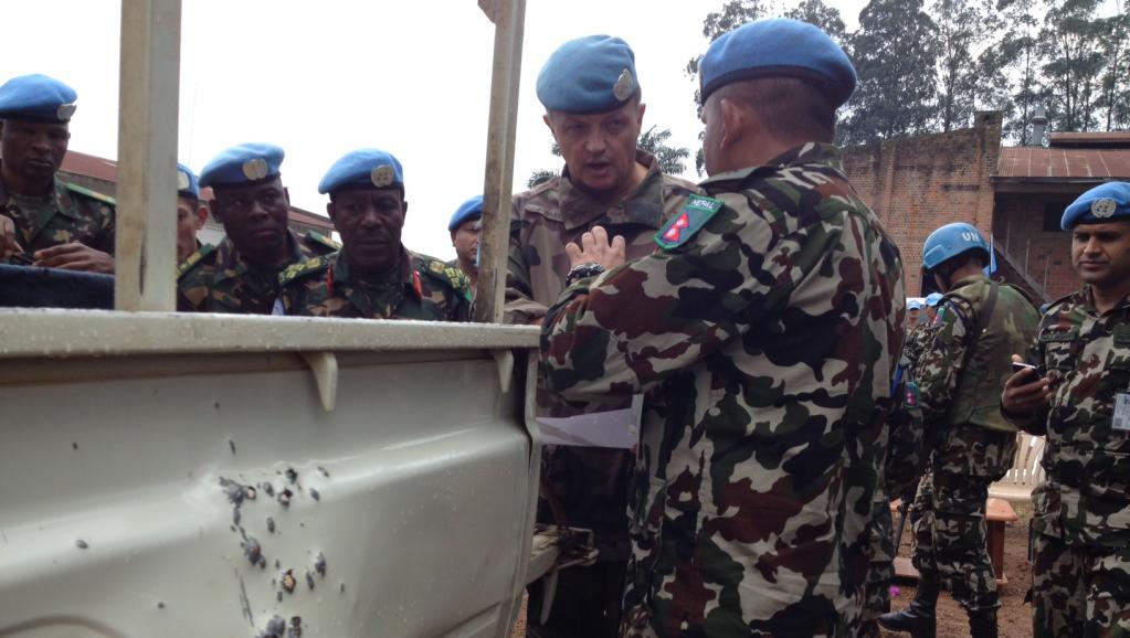 Le général Jean Baillaud, commandant par intérim de la force des Nations unies au Congo et le commandant du bataillon népalais analysent les dégâts causes au véhicule par l'attaque à la grenade non revendiquée de lundi à Béni ayant fait 6 blessés.