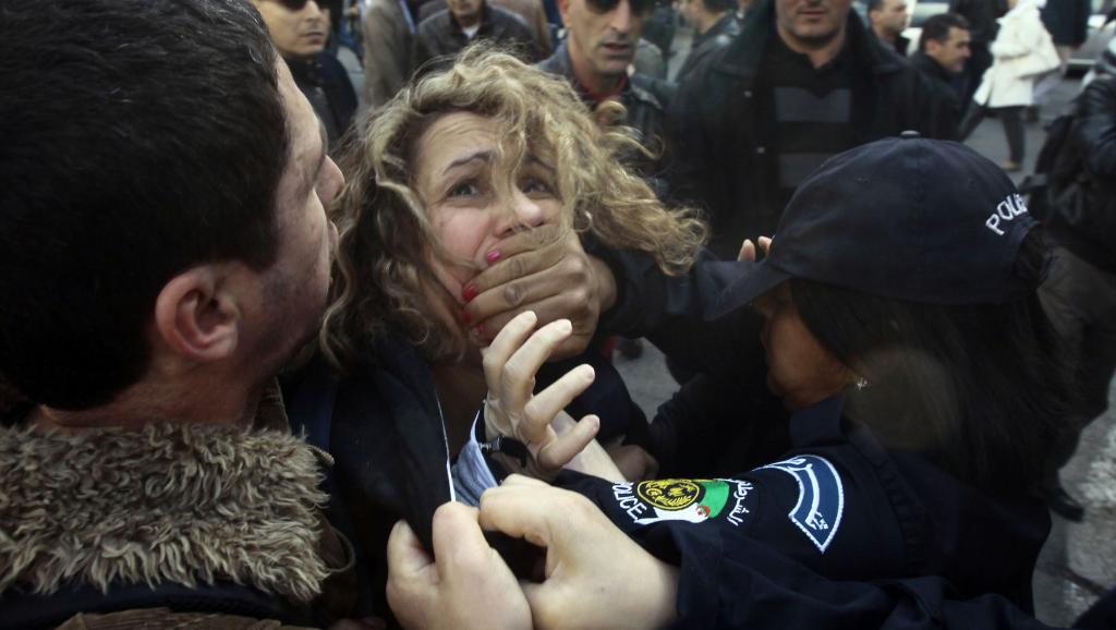 Un policier arrête une manifestante durant un rassemblement à Alger le 6 mars 2014, pour protester contre la candidature d'Abdelaziz Bouteflika pour un 4e mandat présidentiel. REUTERS/Ramzi Boudina