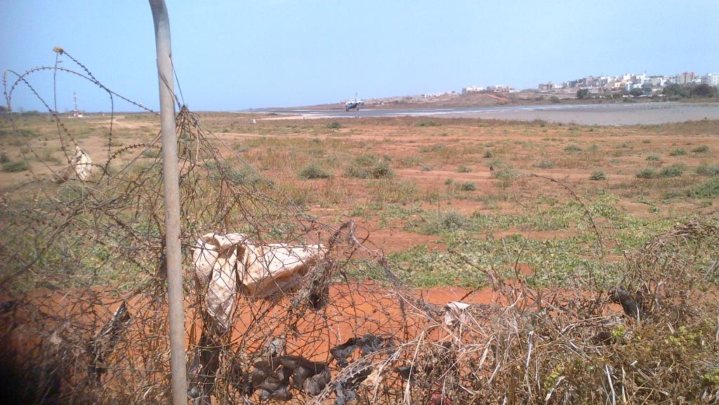 Cité avion, dans le quartier populaire de Ouakam. Derrière une clôture délabrée, affaissée par endroits, la piste est là, à quelques dizaines de mètres seulement