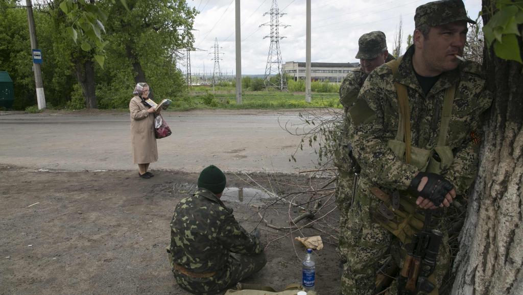 Une femme lit la Bible alors que des séparatistes pro-russes prennent position près de la ville de Slaviansk, à l'est de l'Ukraine, le 5 mai 2014.