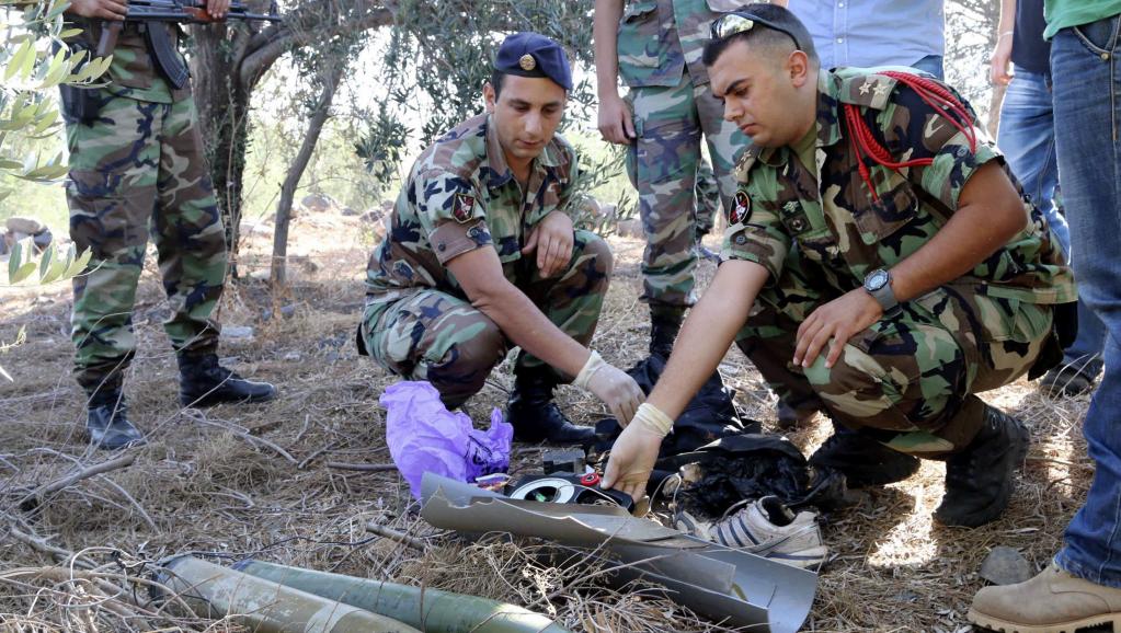 Des soldats libanais inspectent les débris d'un obus qui aurait été tiré du Liban vers Israël, au Sud-Liban, le 11 juillet 2014. REUTERS/Karamallah Daher