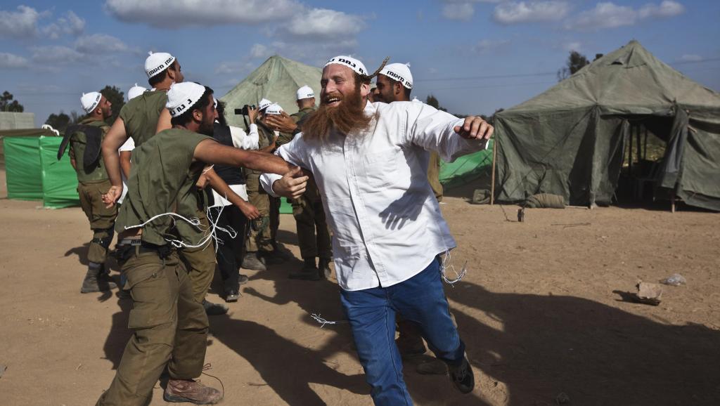 Des Israéliens dansent avec leurs soldats près de la frontière avec la bande de Gaza. REUTERS/Nir Elias