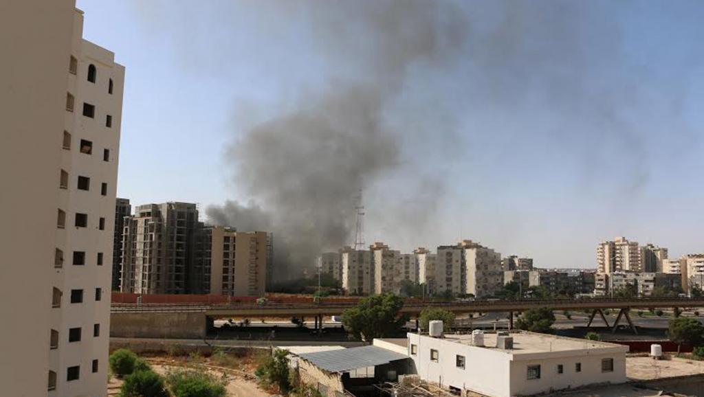 Une épaisse fumée noire s'échappe de l'aéroport de Tripoli, dimanche 13 juillet, après l'attaque lancée par des groupes islamistes. REUTERS/ Hani Amara