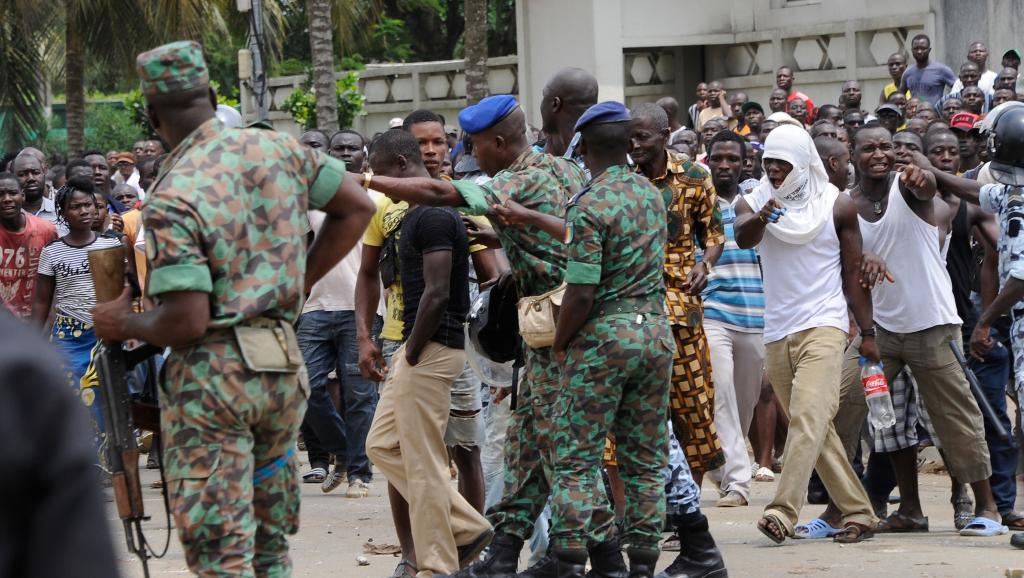 Des soldats face aux habitants du quartier de Gobélé qui manifestent contre la destruction de leurs habitations. Cocody, le 22 juillet 2014. AFP PHOTO/ SIA KAMBOU