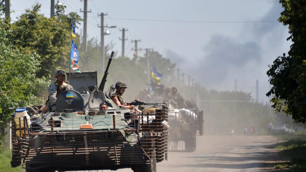 Des militaires ukrainiens entrant dans le village de Verhnyokamyanske, dans la région de Donetsk, le 25 juillet 2014. AFP PHOTO/ GENYA SAVILOV
