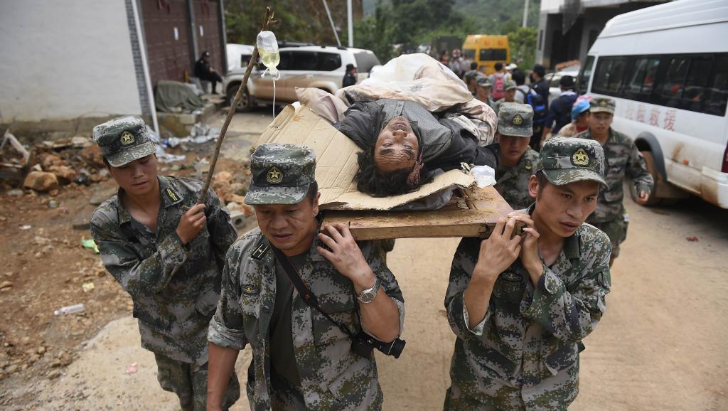 Les secours transportent, sur leurs épaules, une victime du tremblement de terre dans la province de Yunnan, le 4 août 2014.