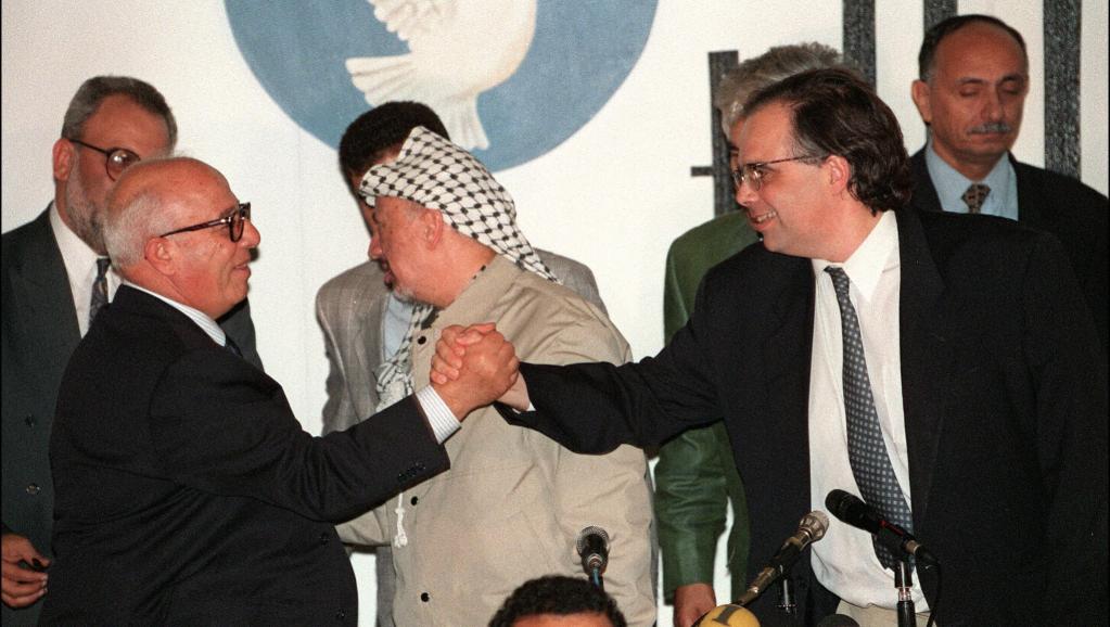 Uri Savir, à droite, sert la main du négociateur palestinien Ahmed Qorei Abu Ala, en septembre 1995. AFP/MENAHEM KAHANA