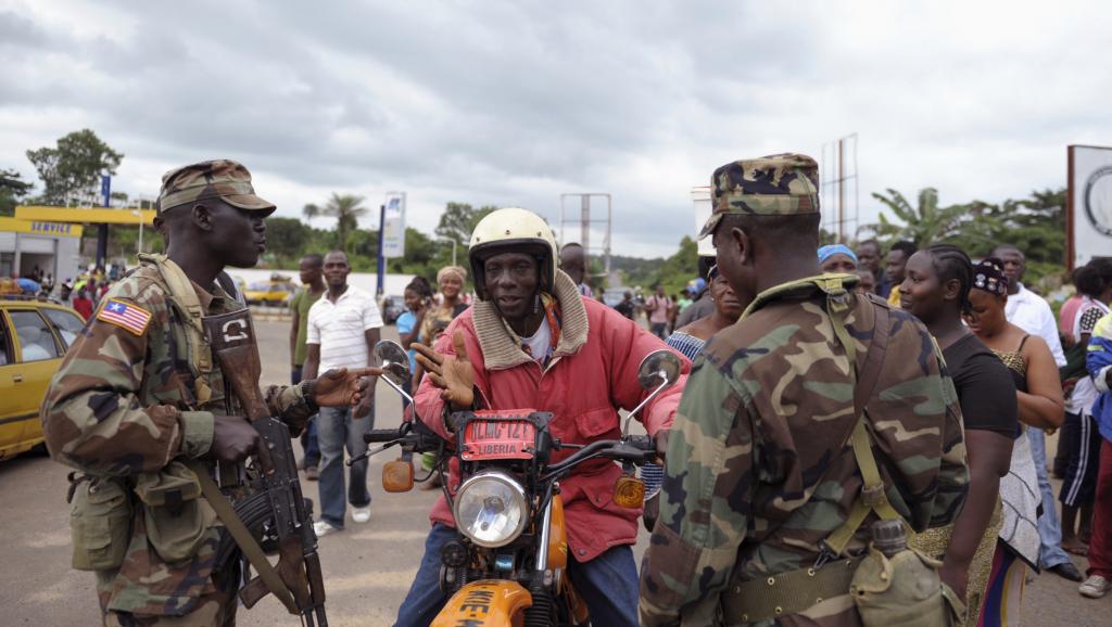 Des soldats libériens contrôlent les habitants du comté de Bomi County, le 11 août 2014. REUTERS/Stringer