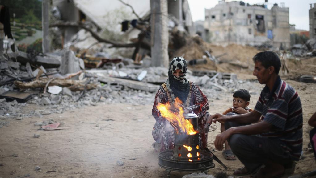 Une famille de Palestiniens prend le thé au milieu des ruines à Gaza, le 18 août 2014. REUTERS/Ibraheem Abu Mustafa