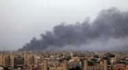 De la fumée s'élève au dessus de la zone des combats entre milices islamistes et troupes du général Khalifa Haftar, non loin de l'aéroport de Benghazi, en Libye, le 23 août 2014.