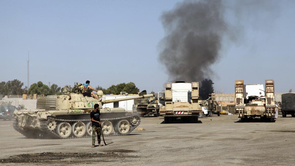 Des combats entre groupes armés dans le quartier général de la Brigade Qaqaa, à Tripoli, le 24 août 2014. REUTERS/Stringer