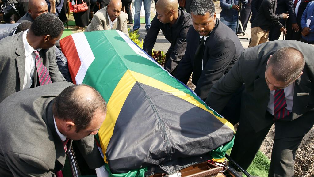 Des porteurs enterrent le cercueil contenant les restes de l'ancien journaliste Nathaniel «Nat» Nakasa au cimetière Heroes Acre le 13 septembre 2014 à Durban. AFP / Rajesh JANTILAL