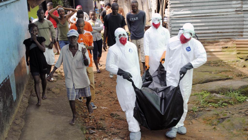 Des membres des services de santé portent le corps d'une personne morte d'Ebola, le 11 septembre 2014. REUTERS/James Giahyue