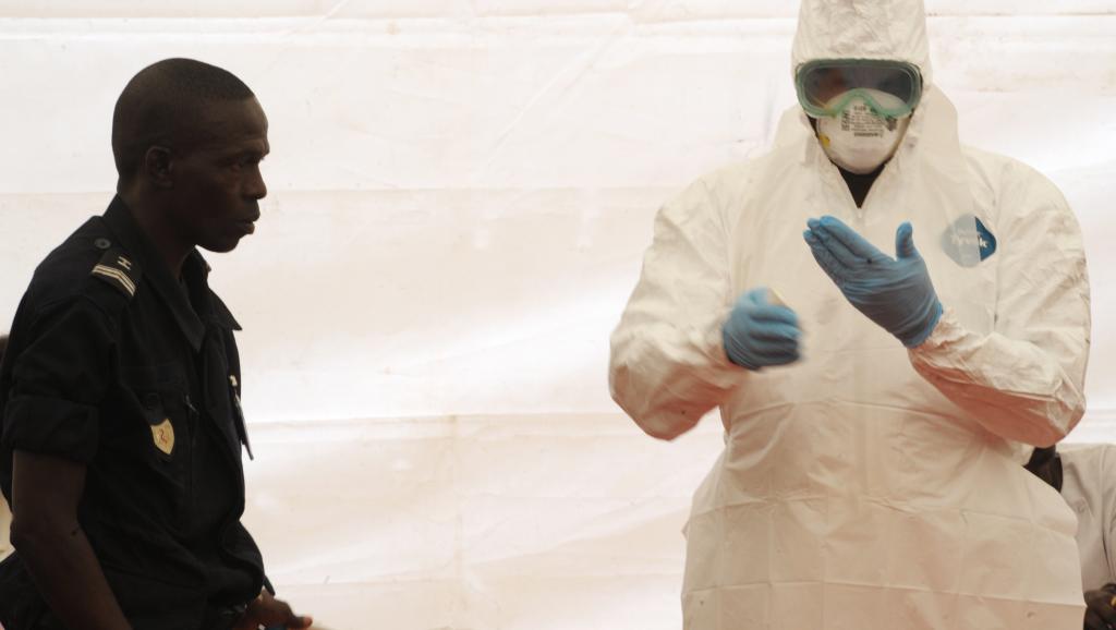 A l'aéroport de Dakar, un personnel sanitaire montre comment s'équiper pour se protéger d'Ebola, le 8 avril 2014. AFP PHOTO / SEYLLOU