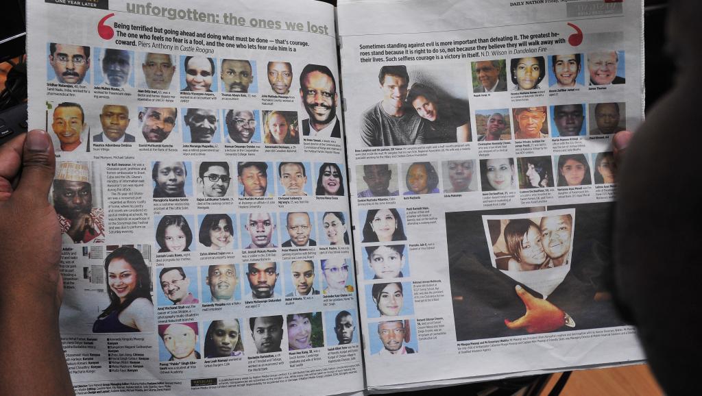 Un homme lit le journal qui publie les portraits des victimes de l'attentat du centre commercial du Westgate. AFP PHOTO / SIMON MAINA