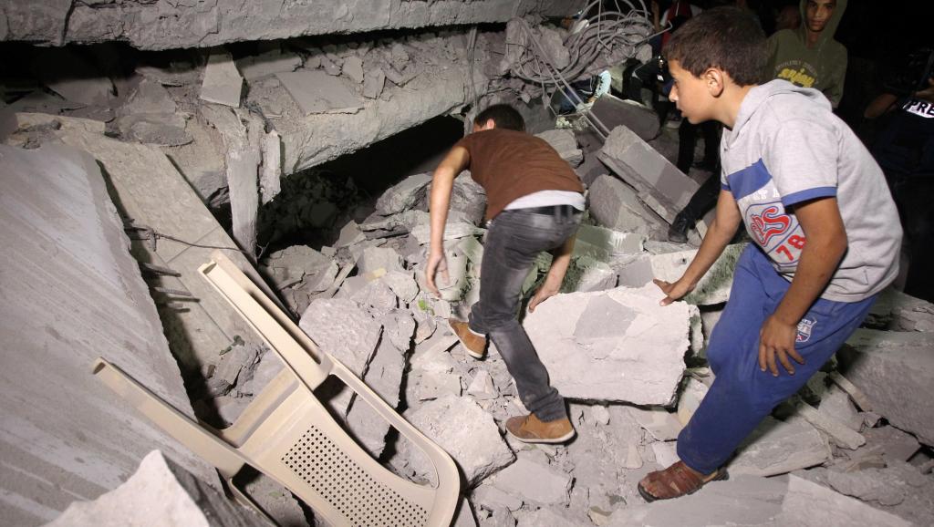Des Palestiniens inspectent ce qu'il reste de la maison de Hussam Qawasmeh, le 18 août 2014,désigné, dès la mi-juillet, comme le principal suspect dans la mort des jeunes Israéliens. AFP PHOTO/ HAZEM BADER