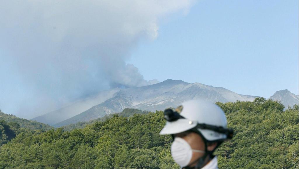 A Kiso, cet officier de police règle la circulation sur une route située au pied du mont Ontake, le 28 septembre 2014.