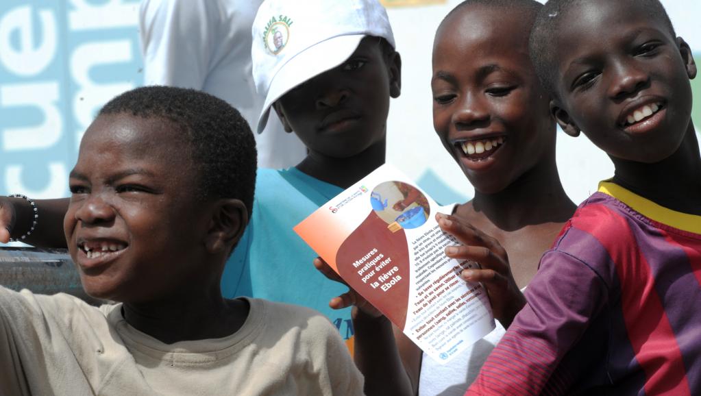 Des garçons lisent une brochure sur la prévention du virus Ebola dans les faubourgs de Dakar, au Sénégal. AFP PHOTO / SEYLLOU