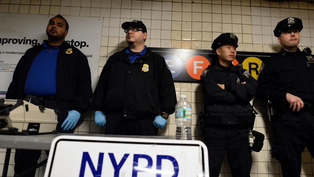 Des officiers de la police new-yorkaise déployés à une station du métro du Queens au lendemain de l'attaque à la hache de Zale Thompson dans ce même quartier, le 24 octobre. AFP PHOTO/Jewel Samad
