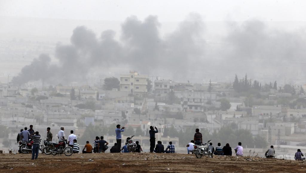 Des Kurdes de Turquie observent les combats qui se livrent à Kobane. REUTERS/Umit Bektas