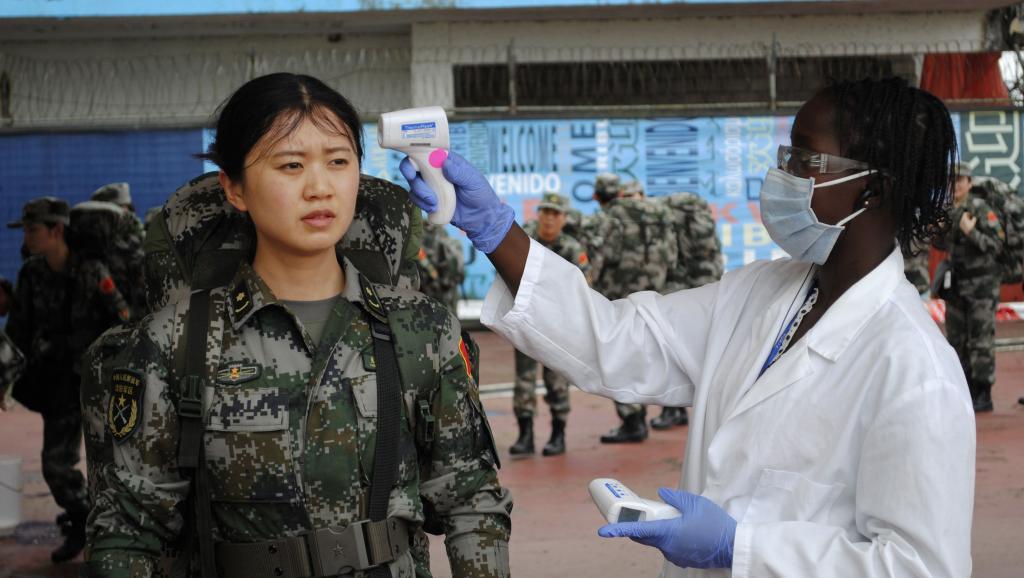Prise de température d'une jeune femme membre du convoi de renforts chinois dans la lutte contre Ebola. Aéroport Roberts à Monrovia, le 15 novembre 2014. REUTERS/James Giahyue