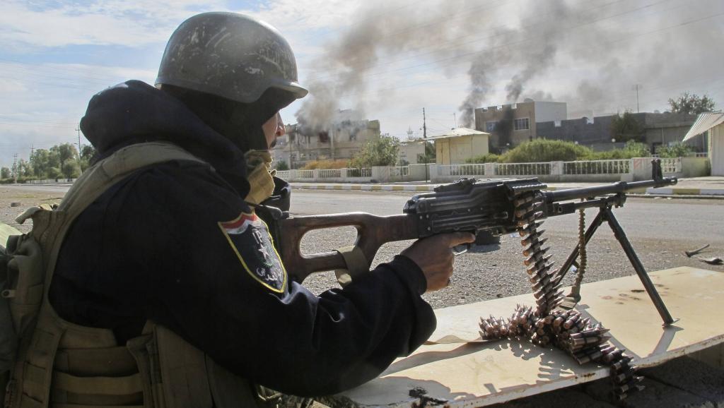 Un membre des forces de sécurité irakiennes tire sur une position islamiste, 115 km au nord de Bagdad, le 24 novembre 2014. REUTERS/Stringer
