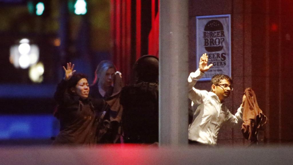 Des otages s'échappent du café après 16 heures de prise d'otage, le 15 décembre 2014. REUTERS/Jason Reed