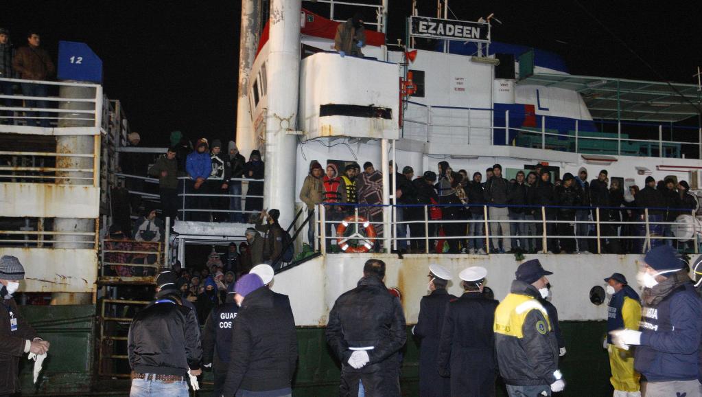 Des migrants attendent de débarquer du cargo Ezadeen au port de Corigliano, le 3 janvier 2015. REUTERS/Antonino Condorelli