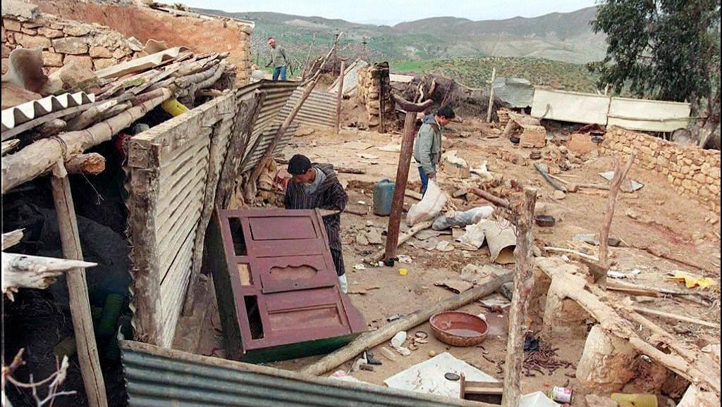 Des survivants du village dévasté de Sahanine (Relizane) où plusieurs habitants ont été tués lors d'une attaque attribuée à des islamistes, le 1er octobre 1998, mais qui serait le fait de la milice de Relizane.