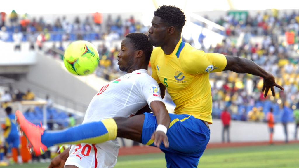Le Gabonais Bruno Ecuele Manga (d.) se heurte au Burkinabè Koffi Ouedraogo, lors d'un match de qualification pour le Mondial, en 2012. AFP PHOTO/YANICK MANIENGUI