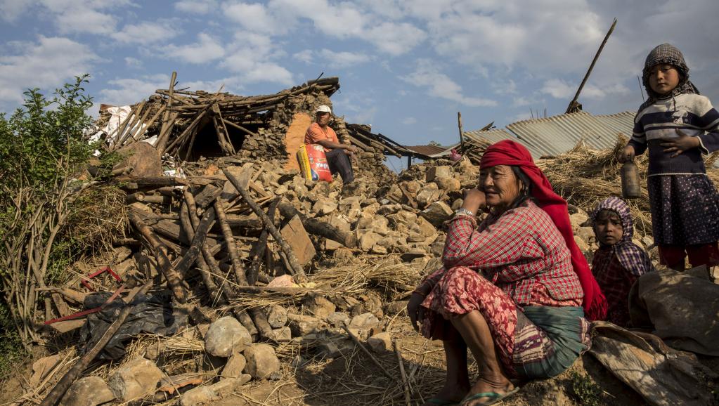 Une Népalaise sur les ruines de sa maison, détruite par le séisme du 25 avril 2015. REUTERS/IFRC/Palani Mohan