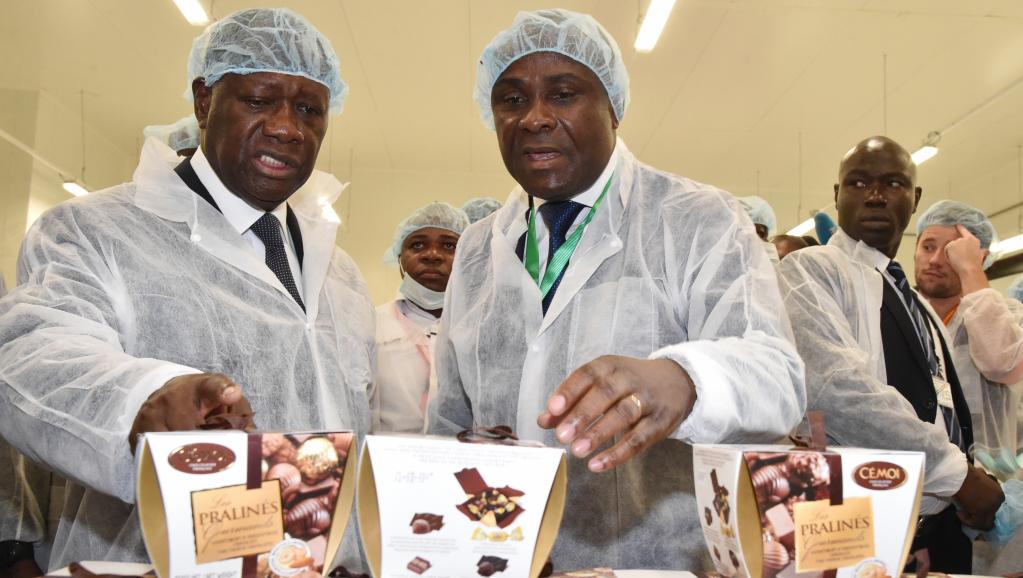 Le président ivoirien Alassane Ouattara (g.) a inauguré la première usine de transformation de beurre de cacao du pays, lundi 18 mai 2015, en présence de Benjamain Bessie (d.), le directeur national du chocolatier Cémoi qui contrôle le site. AFP PHOTO / ISSOUF SANOGO