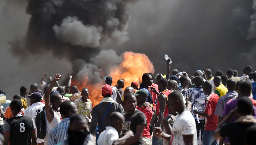 Manifestants devant l’Assemblée nationale en feu à Ouagadougou, Burkina Faso, le 30 octobre 2014. AFP PHOTO / ISSOUF SANOGO