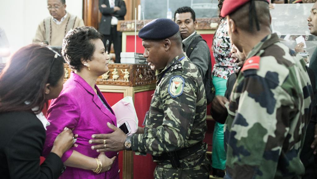 Une députée malgache discute avec un officier des forces de l'ordre lors du vote appelant à la destitution du président, le 26 mai 2015. AFP PHOTO / RIJASOLO